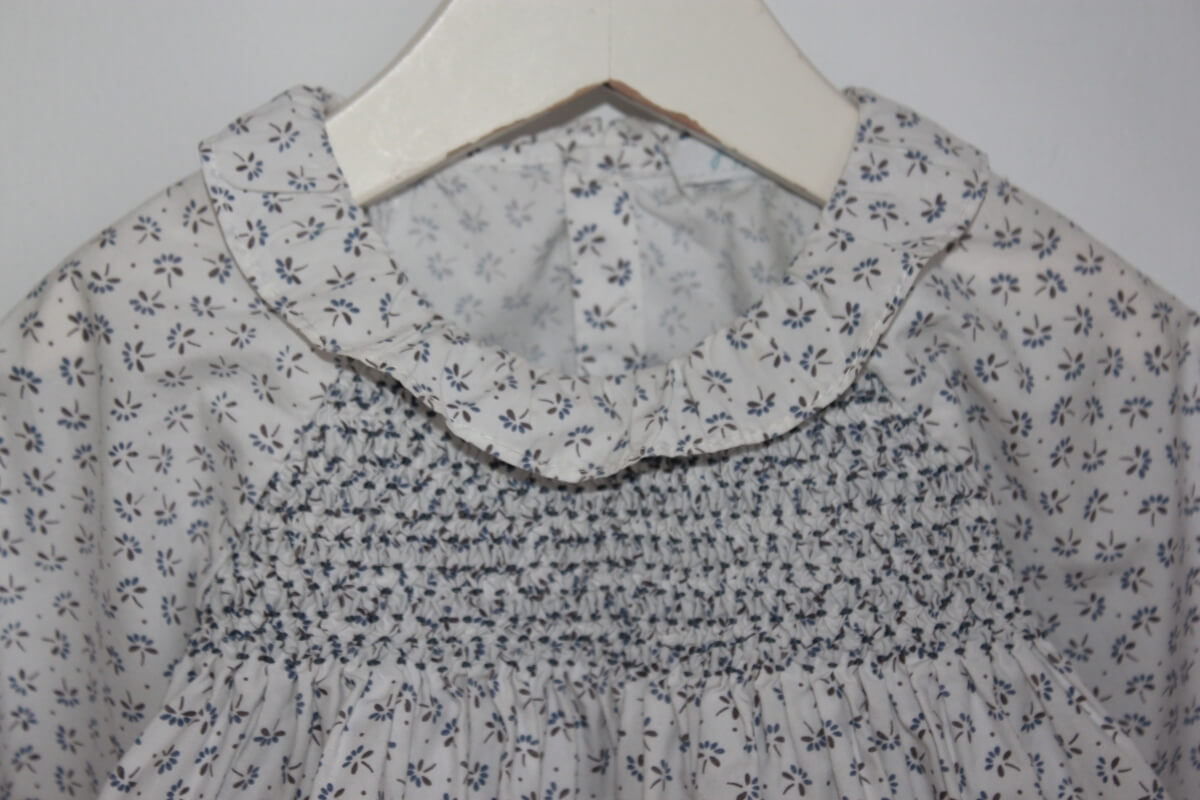 tweedehands katoenen wit met blauw gebloemde gesmokte blouse met lange mouwen voor een baby meisje maat 74 van jacadi