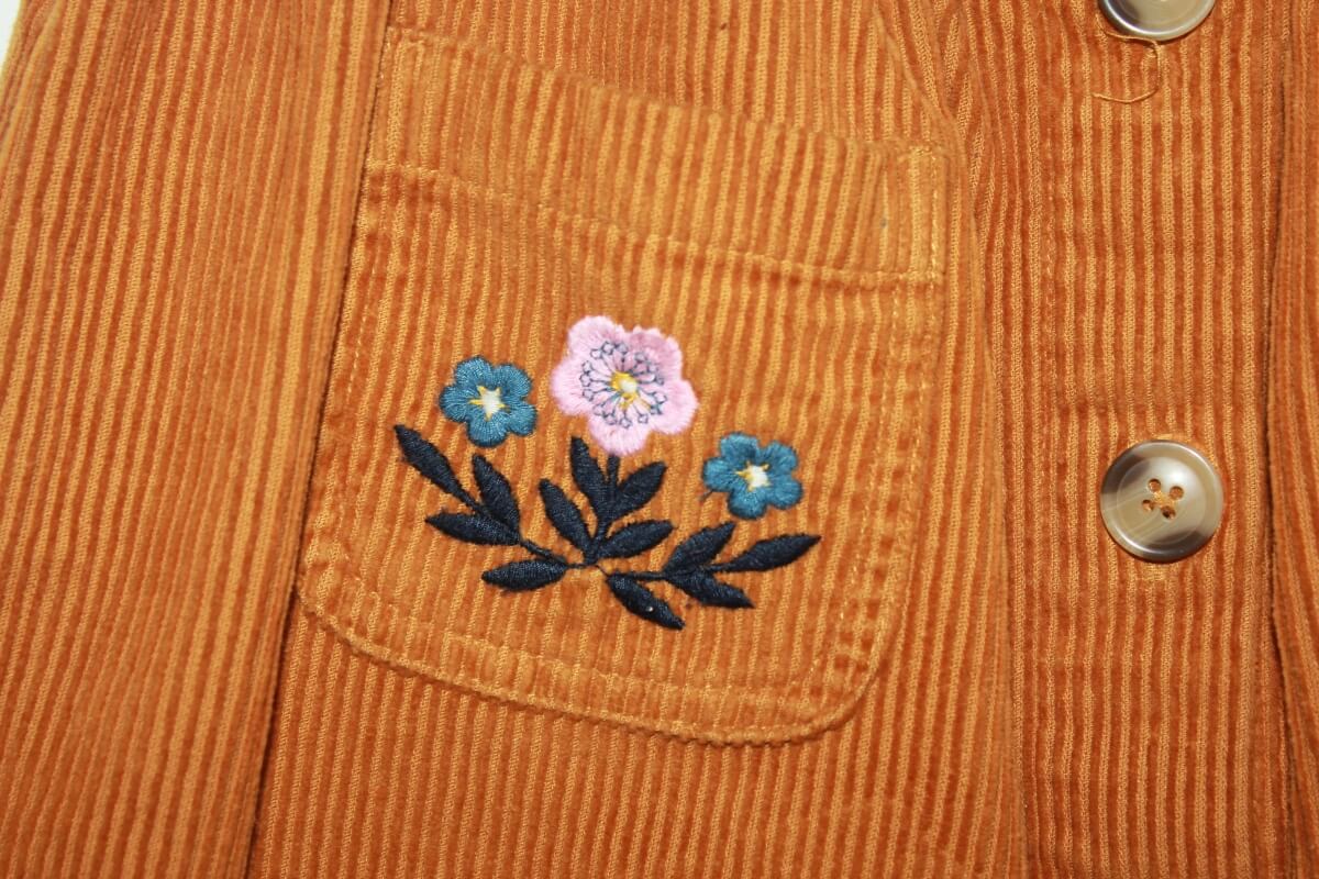 tweedehands katoenen ribfluwelen mosterdgele rok met geborduurde bloemen op de zakjes, van monoprix in maat 116