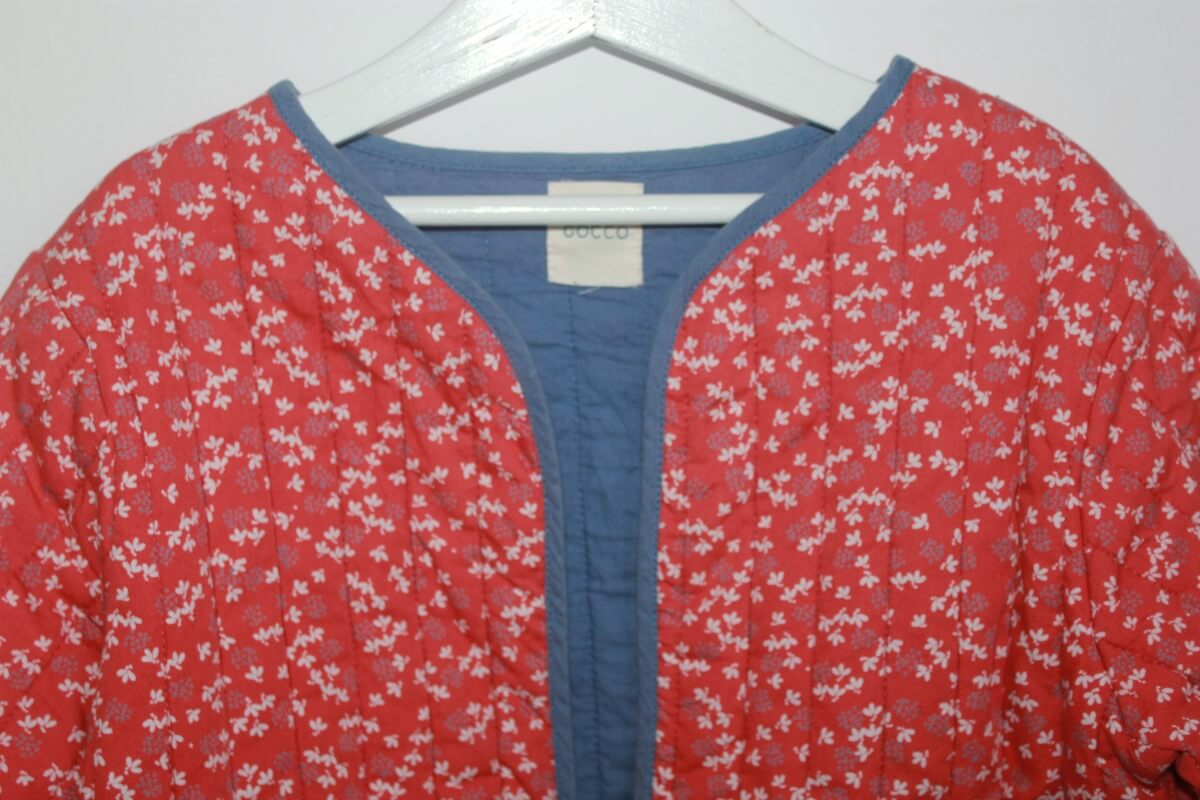 tweedehands katoenen rood met ecru en blauw gebloemd jasje van gocco ,voor het tussenseizoen, in maat 134-140 voor een meisje