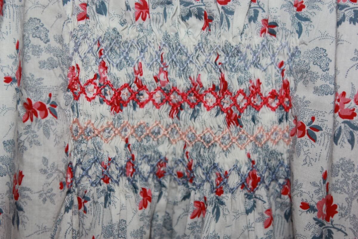 preloved katoenen gesmockte liberty blouse in blauw, rood en wit, met lange mouwen, van bonpoint in maat 152 voor een meisje