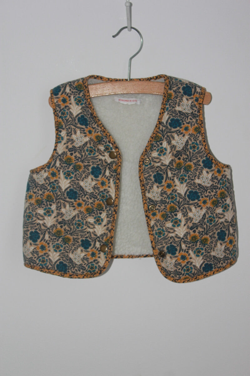 tweedehands gebloemd mouwloos vest in multicolour van monoprix in maat 104 voor een meisje. Gevoerd met imitatie schapenvacht 