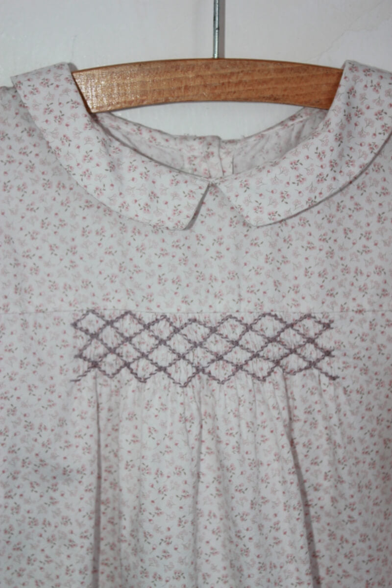 tweedehands katoenen roze-wit gebloemde gesmokte blouse met lange mouwen in maat 128 van bobine