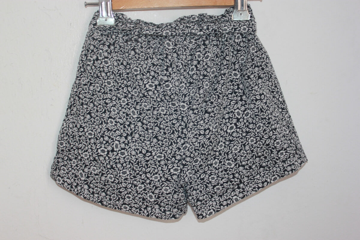 tweedehands zomerse zwart met wit gebloemde korte broek in maat 104 voor een meisje van eden et victor