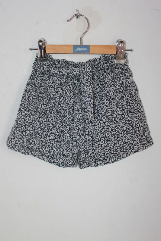tweedehands zomerse zwart met wit gebloemde korte broek in maat 104 voor een meisje van eden et victor