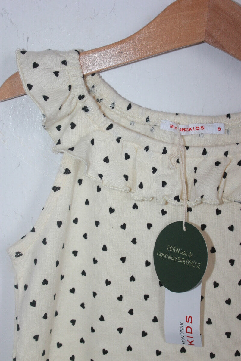 tweedehands creme mouwloze top met zwarte hartjes en een volant in maat 128 van monoprix. 100% bio-katoen