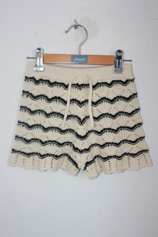 Tweedehands creme met zwarte gebreide korte broek in maat 116 voor een meisje van zara