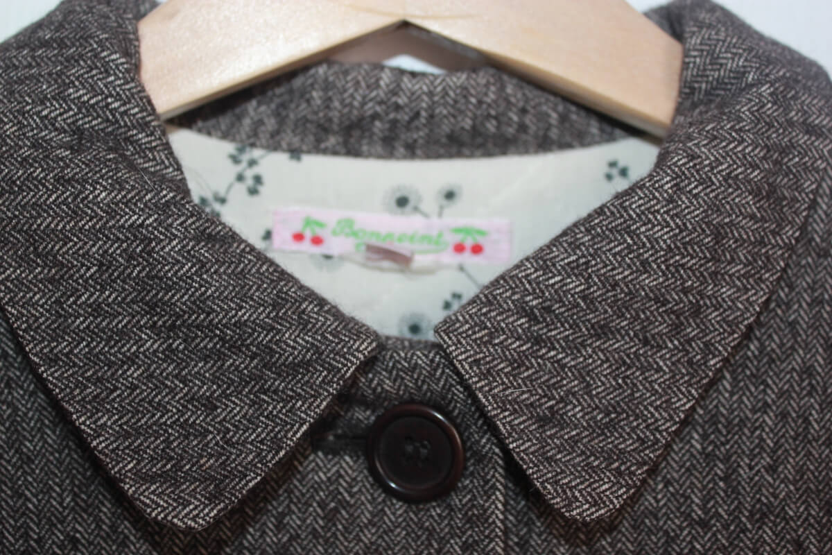 tweedehands bruingrijs en ecru gemeleerde jas van bonpoint in maat 122-128 voor een meisje